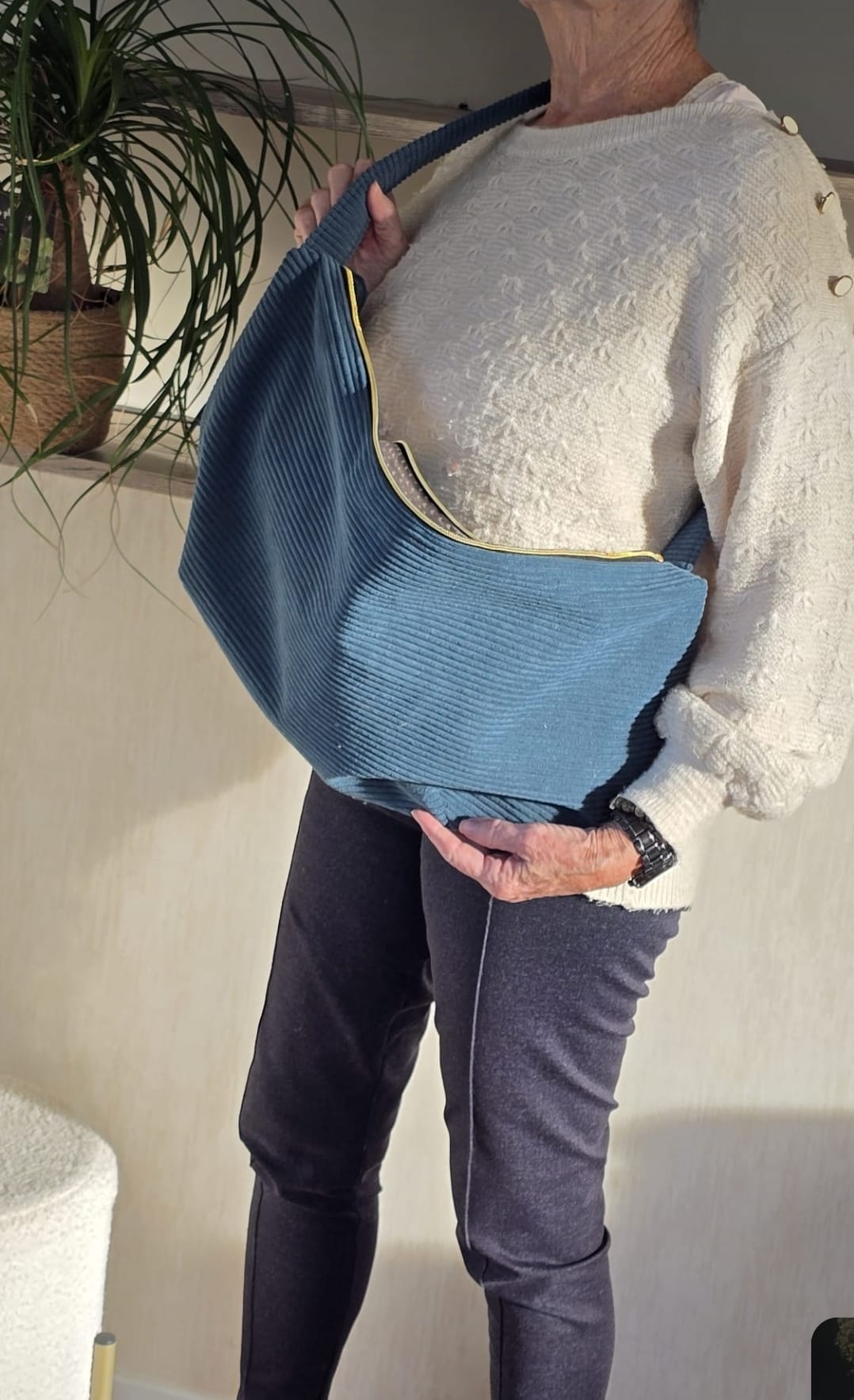 Grand sac bleu côtelé porté à l’épaule, modèle souple et pratique.